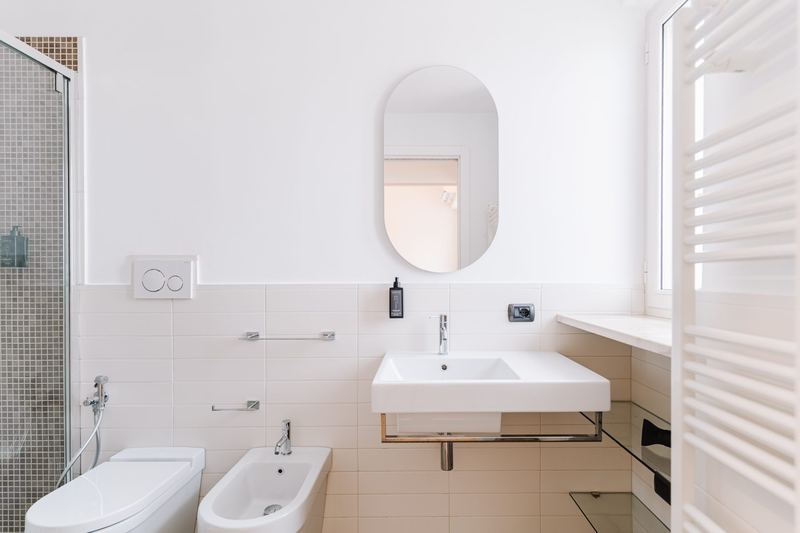 Bagno con lavabo sospeso e specchio ovale