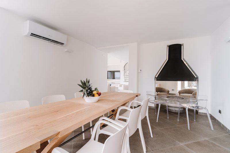 Sala da pranzo interna con camino e grande tavolo
