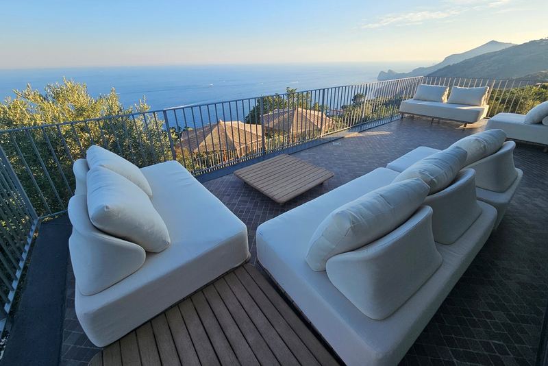 Terrazza lounge con divani bianchi affacciata sul Golfo