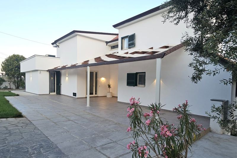 Facciata della villa con pergolato e oleandri in fiore